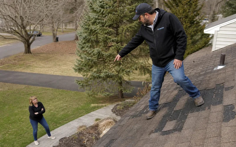 Roofer pointing out damage extent on a Hartford County roof during inspection