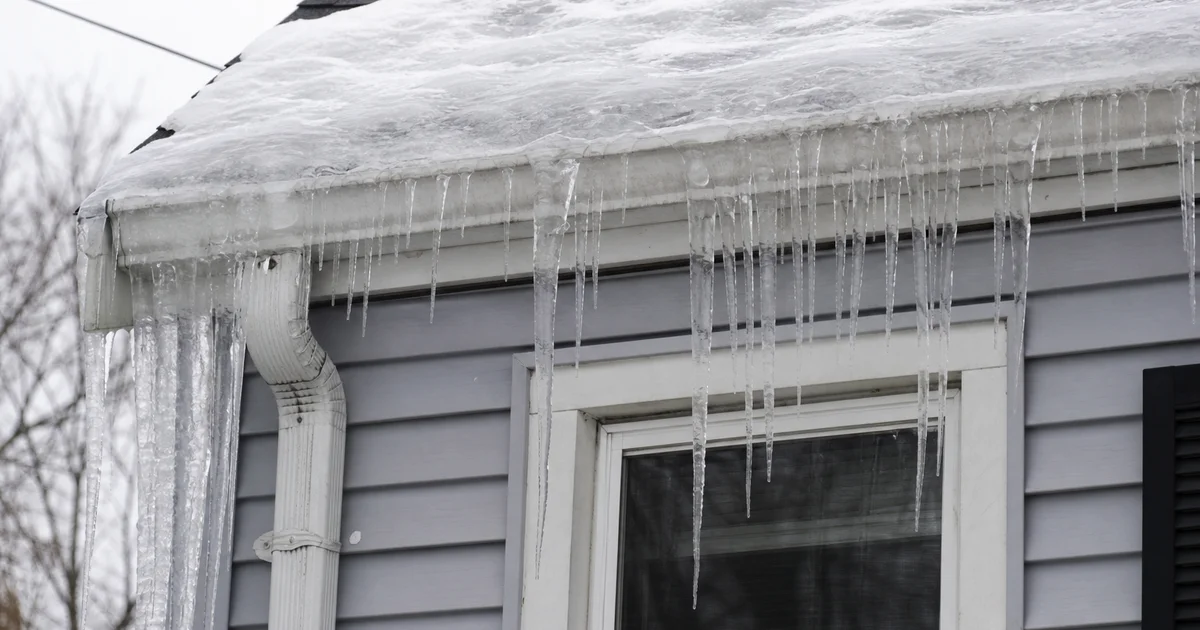 Ice dam at the eave of a Hartford County residential roof in winter, icicles forming