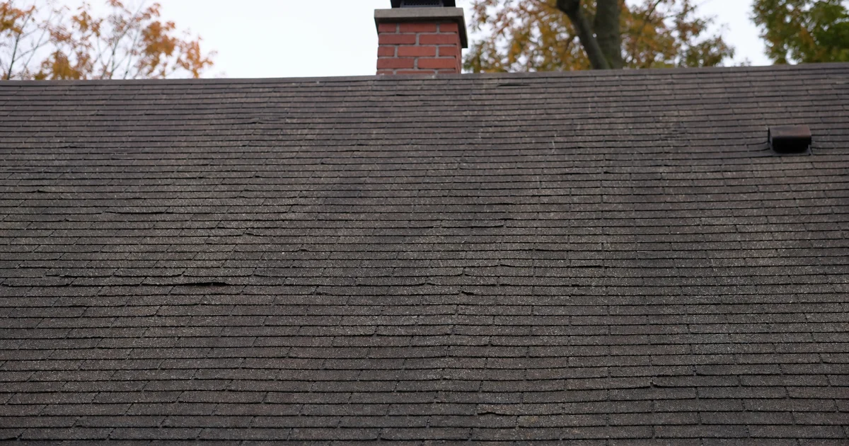 Mature asphalt shingle roof showing age signs on a Hartford County home