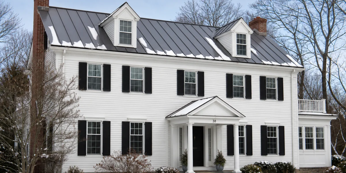 Standing seam metal roof concealed fastener system detail on Connecticut colonial home in winter shedding snow